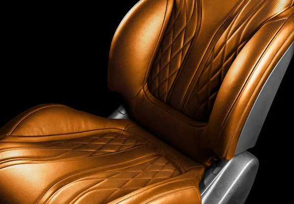 Modern luxury car brown leather interior. Part of orange leather car seat details with white stitching. Interior of prestige car. Comfortable perforated leather seats. Perforated leather.