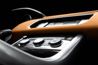 Kahverengi lüks modern araba. Direksiyon, vites kolu ve gösterge paneli. Modern araba iç dekorasyonunun ayrıntıları. Otomatik vites kolu. Pahalı arabada dikilmiş turuncu deri koltuklar.