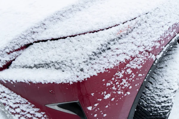 Frozen car. Car covered with snow and frost. Part of the car under snow after a heavy snowfall. The body of the car is covered with snow after blizzard