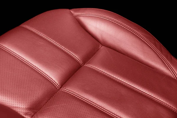 Modern luxury car red leather interior. Part of red perforated leather car seat details with white stitching. Interior of prestige car. Comfortable perforated leather seats. Perforated leather.