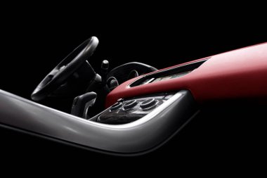 Kırmızı lüks modern araba. Direksiyon, vites kolu ve gösterge paneli. Modern araba iç dekorasyonunun ayrıntıları. Otomatik vites kolu. Pahalı bir arabaya dikilmiş deri koltuklar.