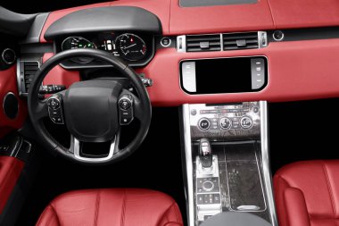 Kırmızı lüks modern araba. Direksiyon, vites kolu ve gösterge paneli. Modern araba iç dekorasyonunun ayrıntıları. Otomatik vites kolu. Pahalı bir arabaya dikilmiş deri koltuklar.