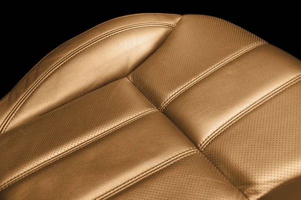 Modern luxury car brown leather interior. Part of orange perforated leather car seat details with white stitching. Interior of prestige car. Comfortable perforated leather seats. Perforated leather.
