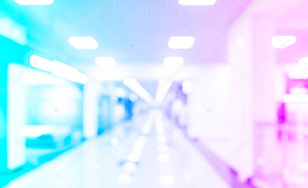 Blurred defocused bokeh background of exhibition hall or convention centre hallway. Blue and pink tones modern interior architecture. Abstract blur modern business office background