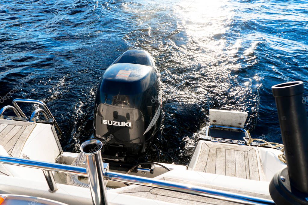 Sankt-Petersburg, Russia, September 23, 2020: Modern fishing sport boat with a brand new Suzuki FourStroke outboard engine speeding on the lake.