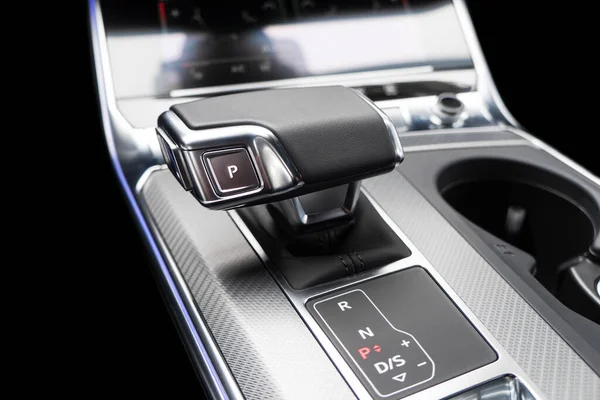 Automatic gear stick of a modern car. Modern car interior details. Close up view. Car inside. Automatic transmission lever shift. Black leather interior with stitching