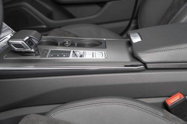 Siyah lüks modern araba. Direksiyon, vites kolu ve gösterge paneli. Modern araba iç dekorasyonunun ayrıntıları. Otomatik vites kolu. Pahalı bir arabaya dikilmiş deri koltuklar.