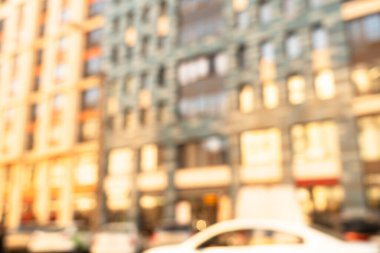 Gün batımında dış görünüşü aydınlanmış, soyut, bulanık bina. Bokeh ışığıyla bulanık modern bina ve güneş ışınlarıyla çözünmüş noktalar. Arkaplan için bulanık pencereler