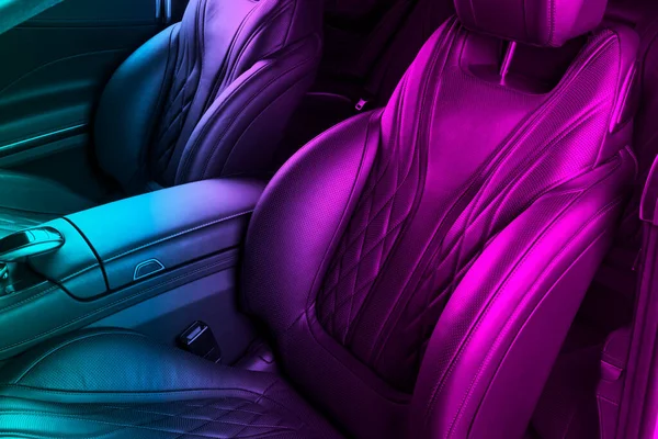 Modern Luxury car inside. Interior of prestige modern car in blue and pink tones. Comfortable leather seats. Perforarated leather. Modern car interior. Car inside