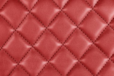 Modern luxury car red leather interior. Part of perforated leather car seat details. Red perforated leather texture background. Texture, artificial leather with diagonal stitching. Leather seats
