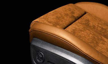 Modern lüks araba kahverengi deri ve alcantara iç döşeme. Turuncu delikli deri koltuk detaylarıyla beyaz dikişli. Prestij arabasının içi. Rahat delikli deri koltuklar..