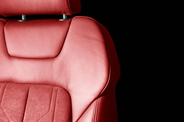 Modern luxury car red leather with alcantara interior. Part of red leather car seat details with white stitching. Interior of prestige car. Perforated leather seats isolated. Perforated leather.