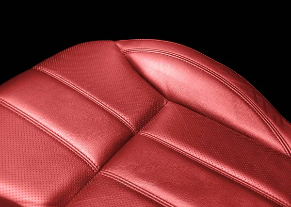 Modern luxury car red leather interior. Part of red perforated leather car seat details with white stitching. Interior of prestige car. Comfortable perforated leather seats. Perforated leather.