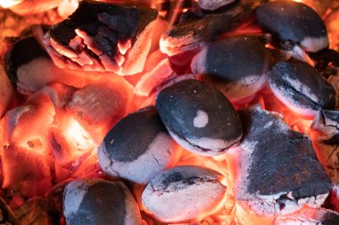 Odunla dolu sıcak bir şömine. Yanan kütüklerin doku arka planından gerçek alevler. Şömine arka planı. Ateş yakın..