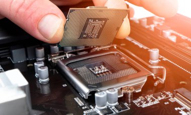 Elektronik mühendisi mikroişlemci yüklüyor. Bakım bilgisayarı işlemci donanımı. Bir bilgisayar işlemci çipi tutuyor. Merkezi işlemciyi bir sokete yerleştirmek