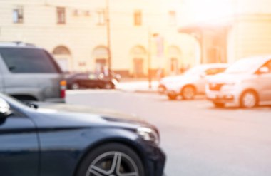 Arka planda bulanık, arabaların olduğu bir yer. Bokeh arka planı aydınlatıyor. Arka plan için soyut bulanık araba otoparkı. Bulanık arabalar park ediyor. Bokeh ışığı 