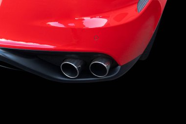 Bir arabanın çift egzoz borusunu kapatın. Kırmızı, modern bir spor arabanın çift egzoz boruları. Arabanın dış detayları. Egzoz borusu olan yeni araba parçaları