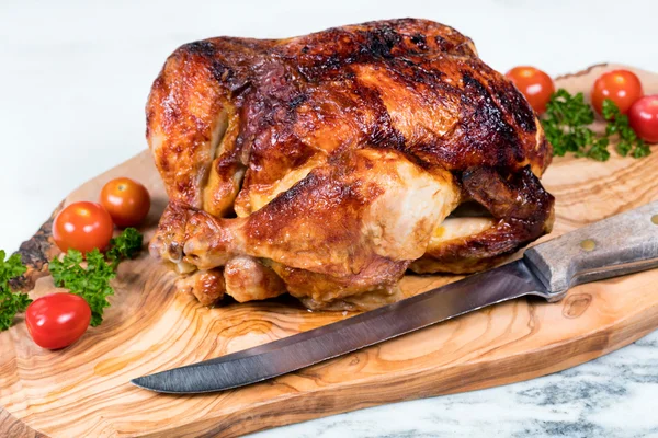 Grande pollo intero pronto per essere scolpito su scheda server in legno — Foto Stock