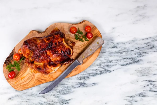 Pollo entero grande listo para ser servido sobre tabla de madera — Foto de Stock