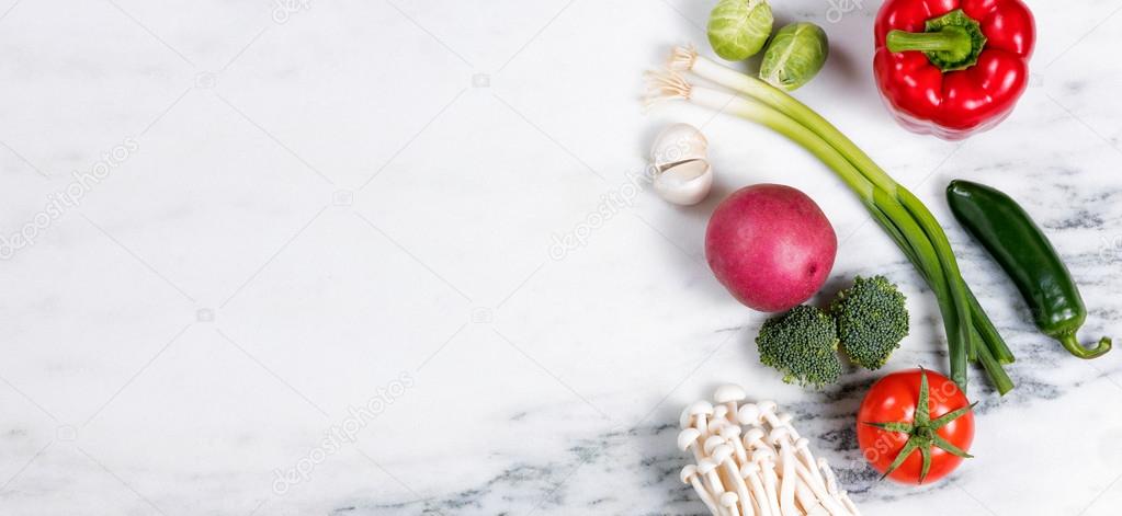 Fresh whole vegetables and fruit on natural marble stone backgro