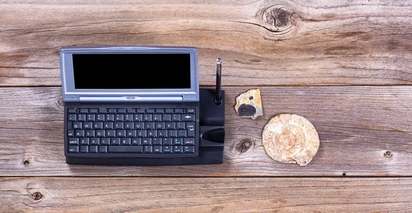 Vintage computer en stenen fossielen op rustieke houten planken — Stockfoto