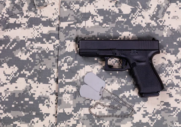 Camuflaje uniforme vestido de batalla con etiquetas de identificación y pistola — Foto de Stock