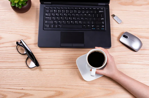 Configuración de escritorio de oficina con la mano femenina que sostiene la taza de café —  Fotos de Stock