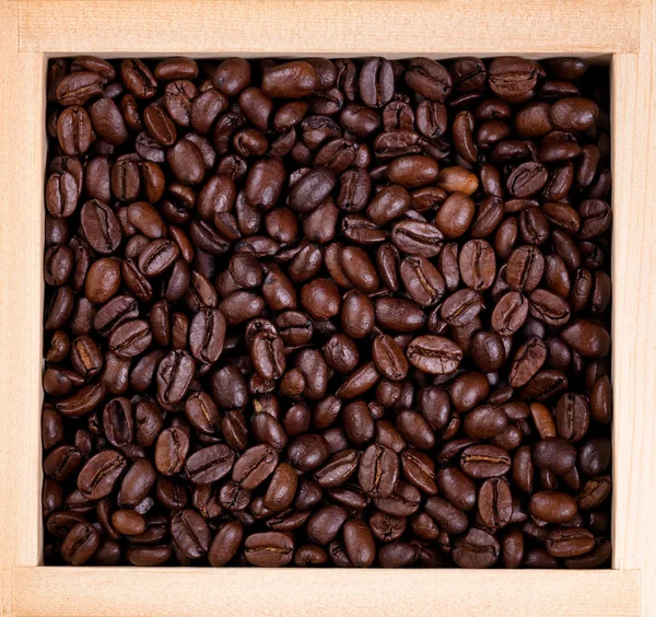 Freshly roasted coffee beans in wooden box frame — Stock Photo, Image