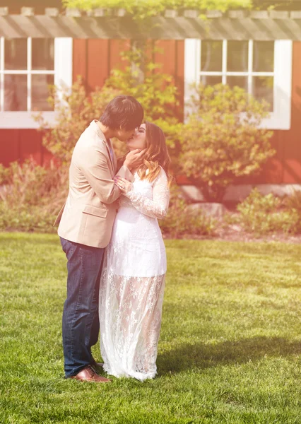 Verwacht van pappa en mamma zoenen in warme daglicht buiten — Stockfoto