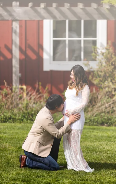 Futuro bebê recebendo beijo do pai como mãe relógios — Fotografia de Stock