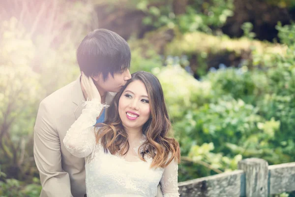 Expecting mom receiving kiss from her husband while outdoors — Stock Photo, Image