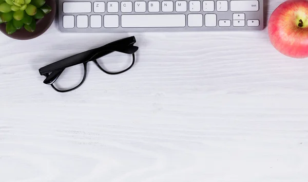 Objetos de trabalho de escritório e frutas no fundo do desktop branco limpo — Fotografia de Stock