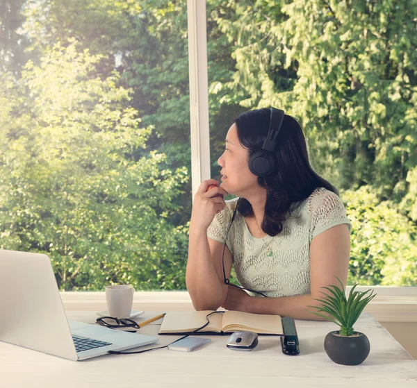 Vrouw thuis werken terwijl u uitkijkt bij helder daglicht van — Stockfoto
