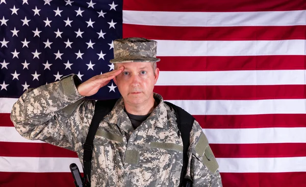 Varón veterano soldado saludando con bandera de EE.UU. en segundo plano mientras — Foto de Stock