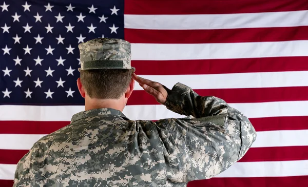 Ветеран мужского пола салютует флагу США — стоковое фото