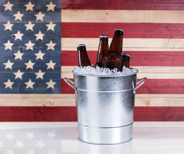 Ведро холодного пива с флагом США на заднем плане — стоковое фото