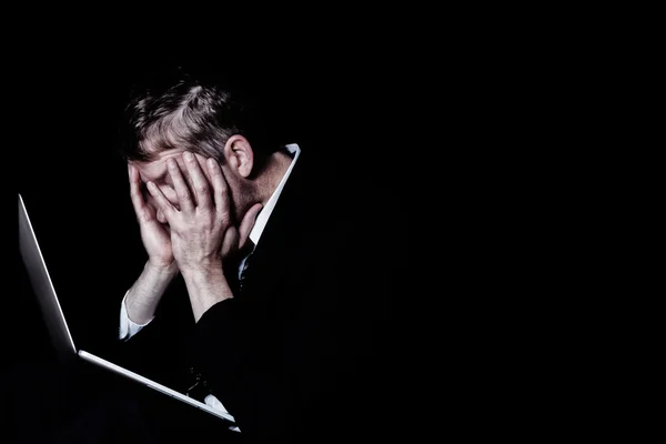 Hombre fuertemente estresado trabajando en la oscuridad —  Fotos de Stock