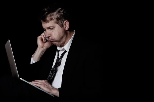 Zdůraznil zralý muž poslouchá na mobil při práci na klíně — Stock fotografie