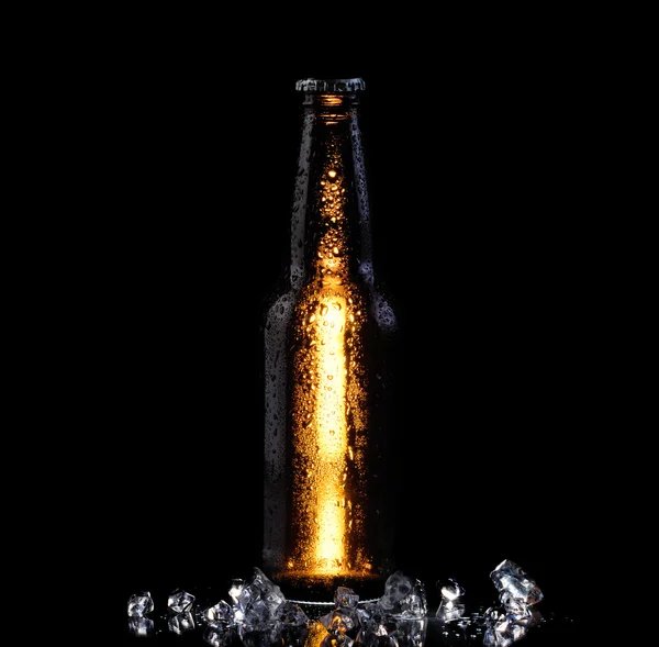 Garrafa gelada de cerveja no fundo preto — Fotografia de Stock