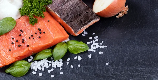 Filete de salmón rey salvaje y hierbas frescas en engaste de piedra negra — Foto de Stock