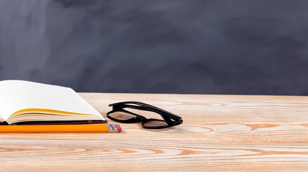 Back to school basic objects in front of erased black chalkboard — Stock Photo, Image