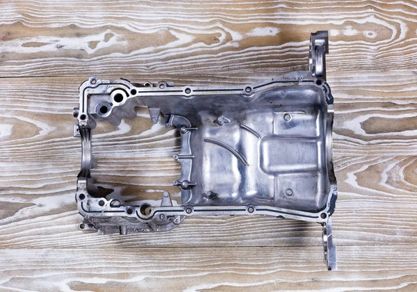 Defected aluminum car engine oil pan with cracks — Stock Photo, Image