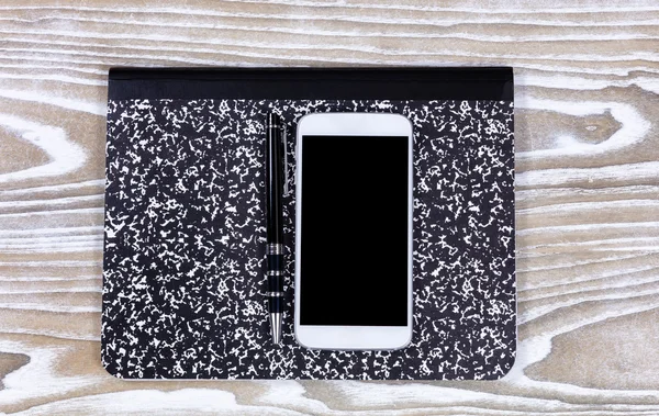 Notepad with pen and cellphone on top of old white desktop — Stock Photo, Image