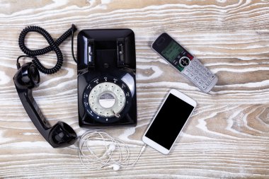 Retro telefon ile modern iletişim aygıt soluk ahşap üzerine 