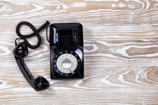 褪了色的木质表面上的复古电话 — 图库照片