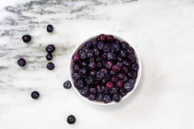 Mermer taş zemin üzerine beyaz kase taze yaban mersini 