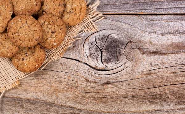 新鲜出炉的燕麦饼干对亚麻织物与仿古木巴 — 图库照片