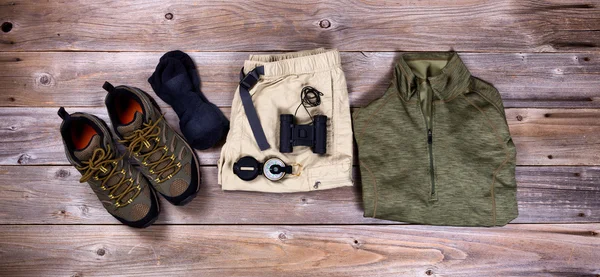 Hiking gear and clothing on rustic wooden boards — Stock Photo, Image