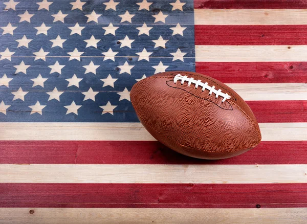 American football on rustic wooden USA flag