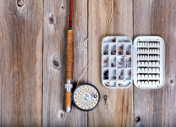 Vintage attrezzature da pesca a mosca e contenitore esca su legno rustico — Foto Stock